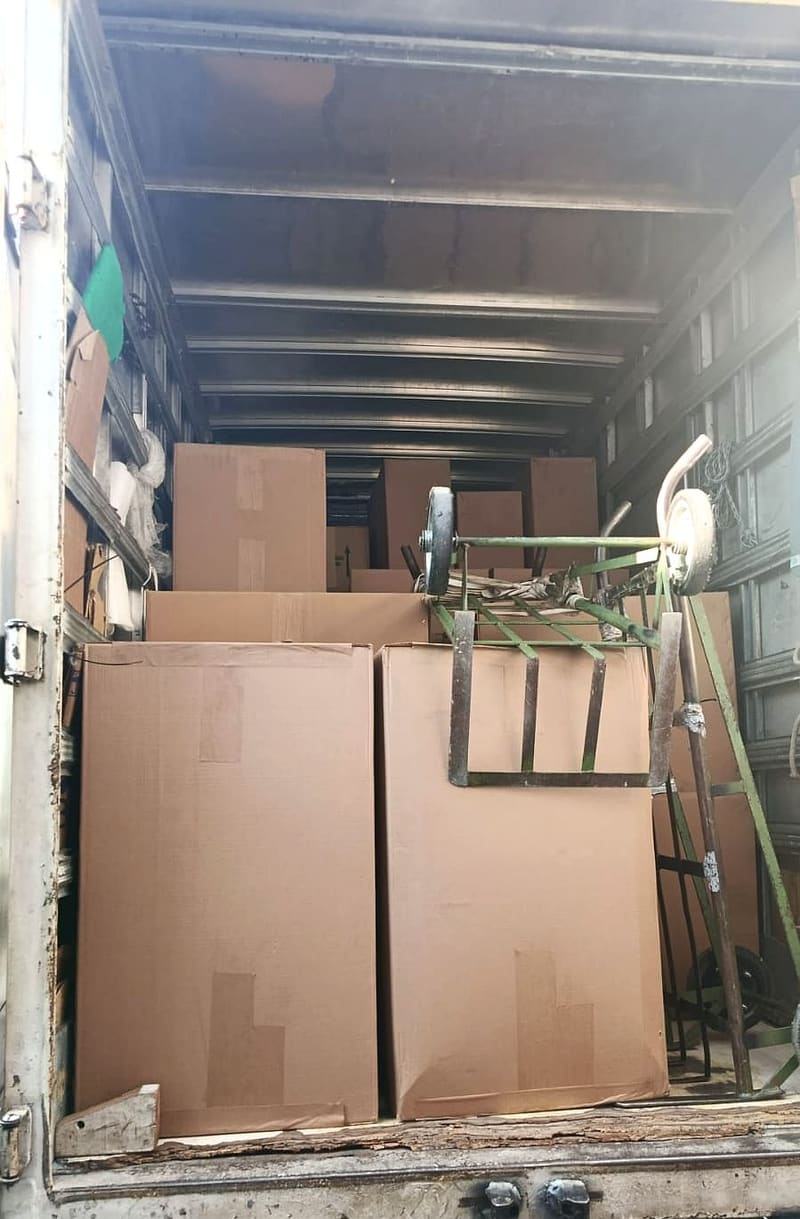 Caixas de papelão organizadas dentro do caminhão da Villa Transportes