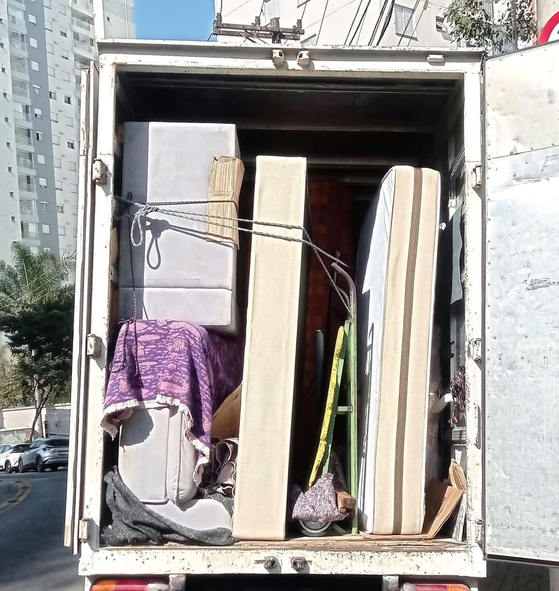 Sofá, colchões e escada amarrados dentro do caminhão da Villa Transportes